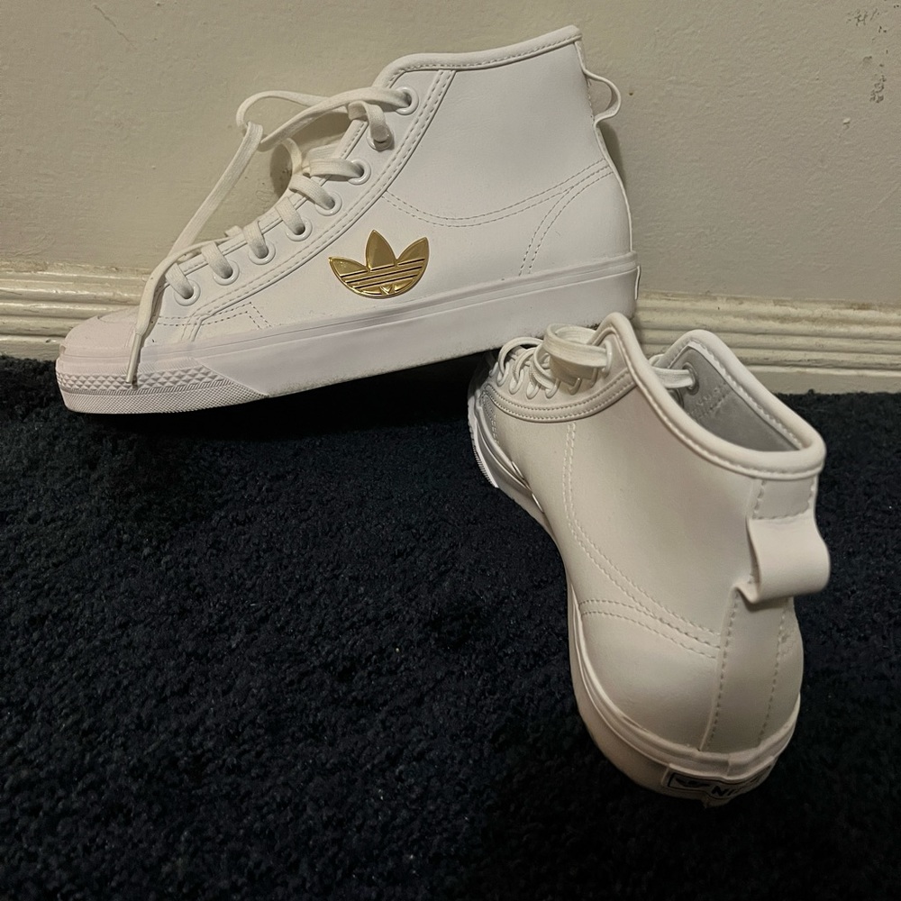 These are Adidas Nizza Trefoil Hi Cloud shoes in White and metallic gold.